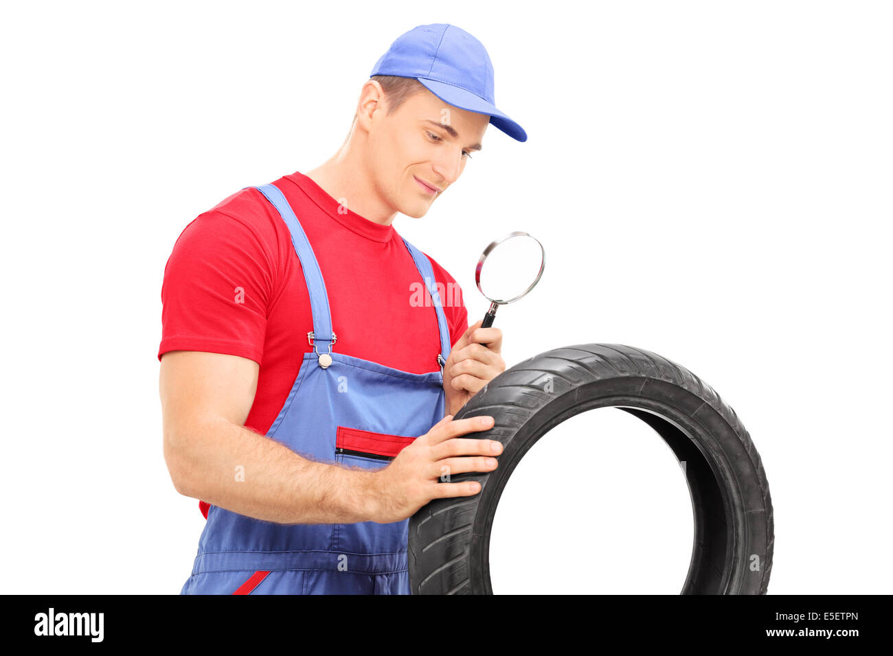 Mechanic examining tire through magnifying glass Stock Photo