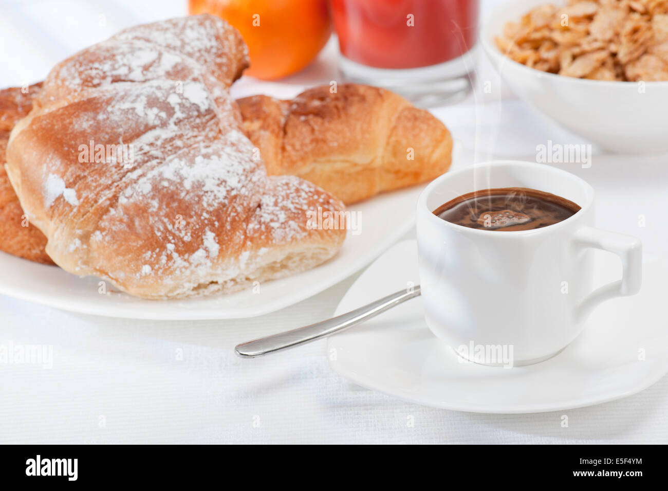 continental breakfast with cup of coffee, fresh croissants, orange