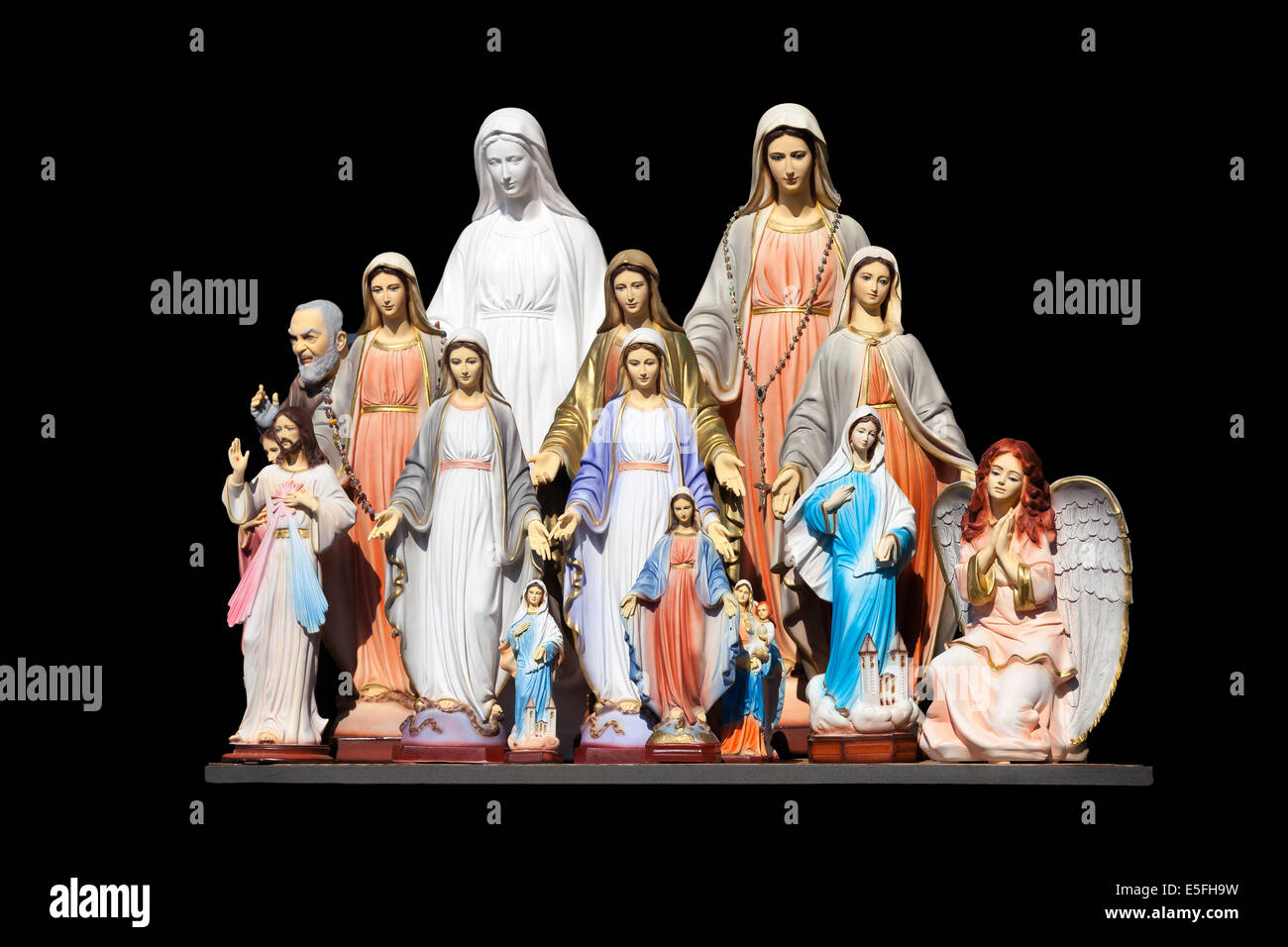 Many statues of the Virgin Mary on a black background. Stock Photo