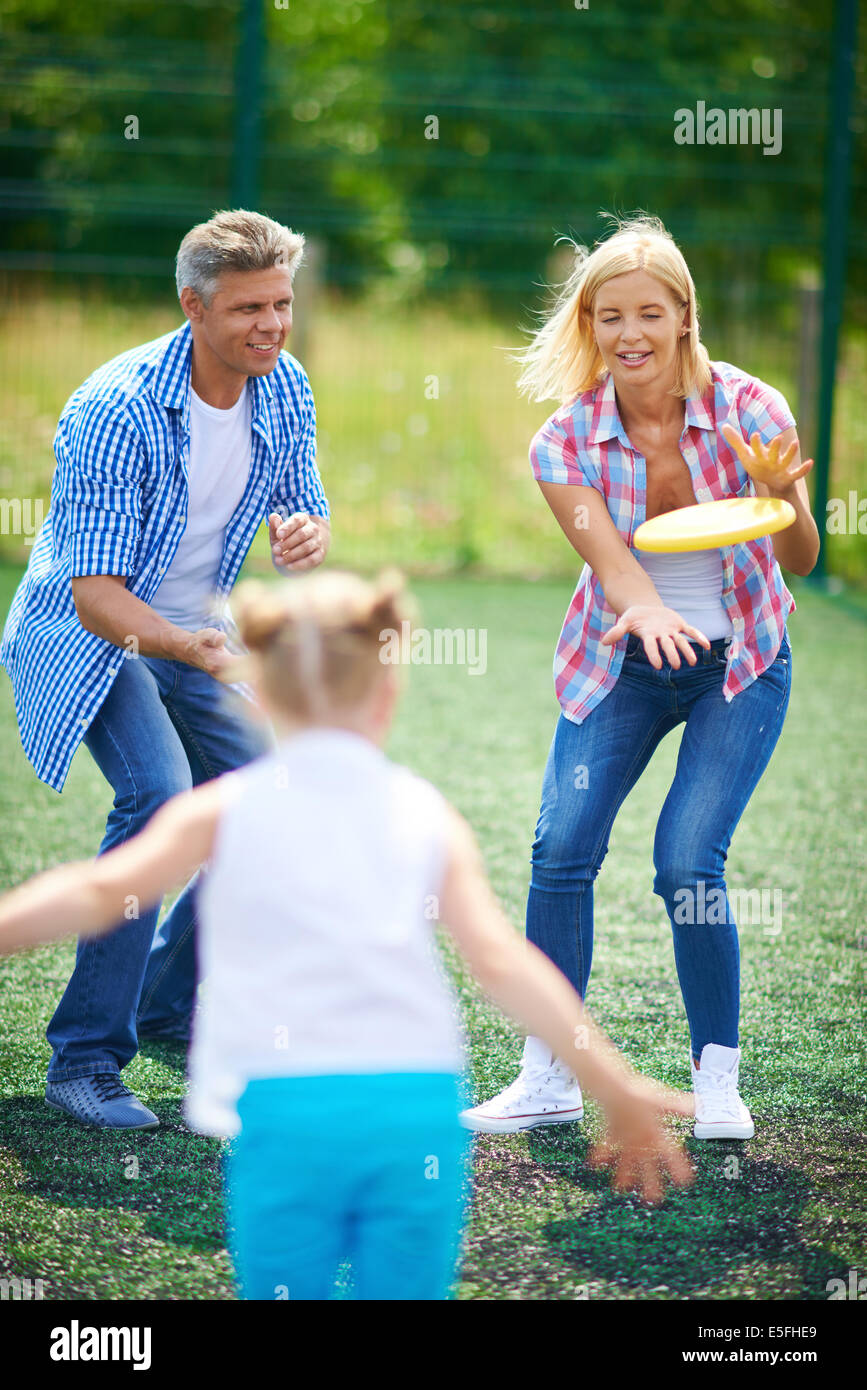 Young family playing with flying disc in the countryside Stock Photo