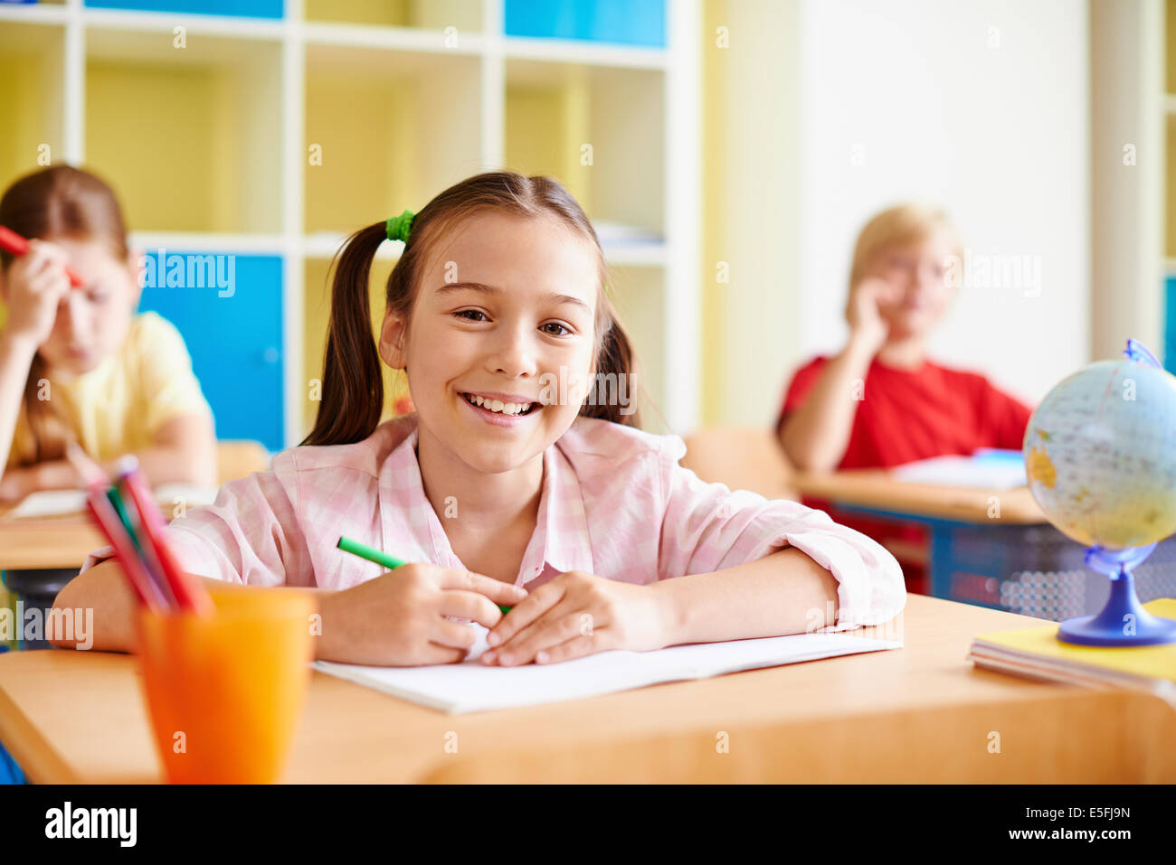 Portrait of lovely girl looking at camera while drawing at lesson Stock ...