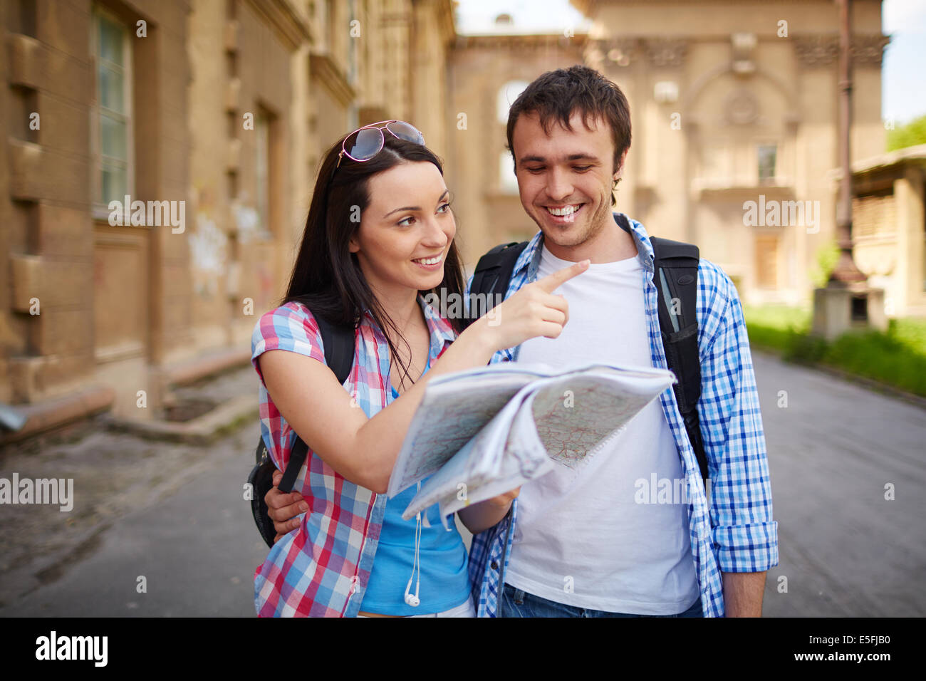 Couple of travelers with map of ancient town deciding where to go Stock Photo
