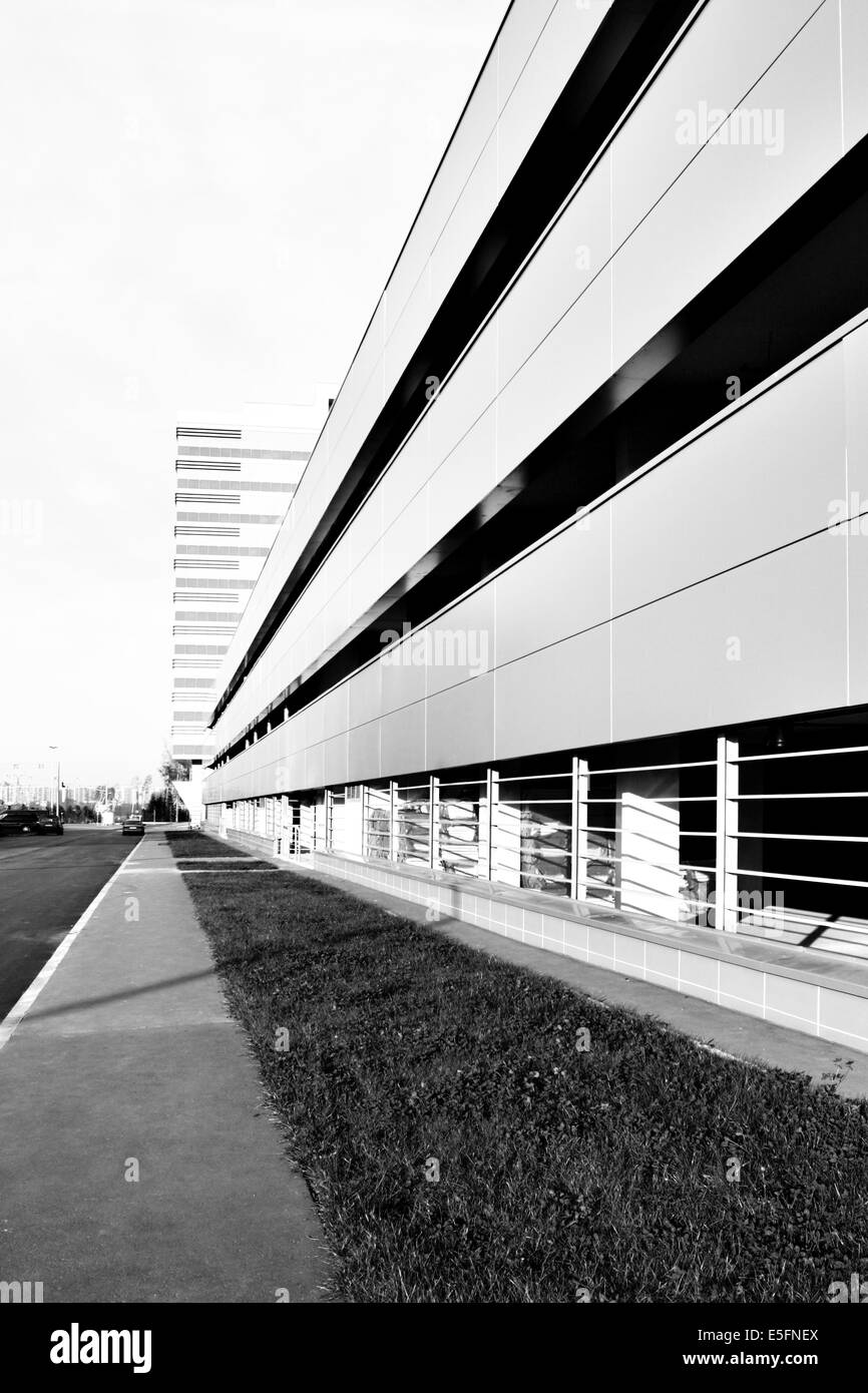 Perspective of car parking near office building. Black and white image Stock Photo