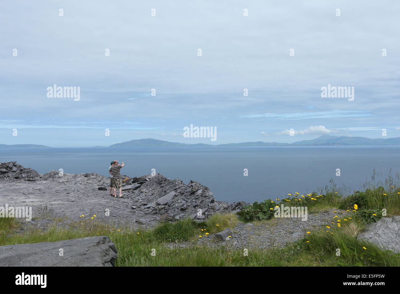 A couple take photographs of the sea on Valentia Island, County Kerry in the South of Ireland. Stock Photo