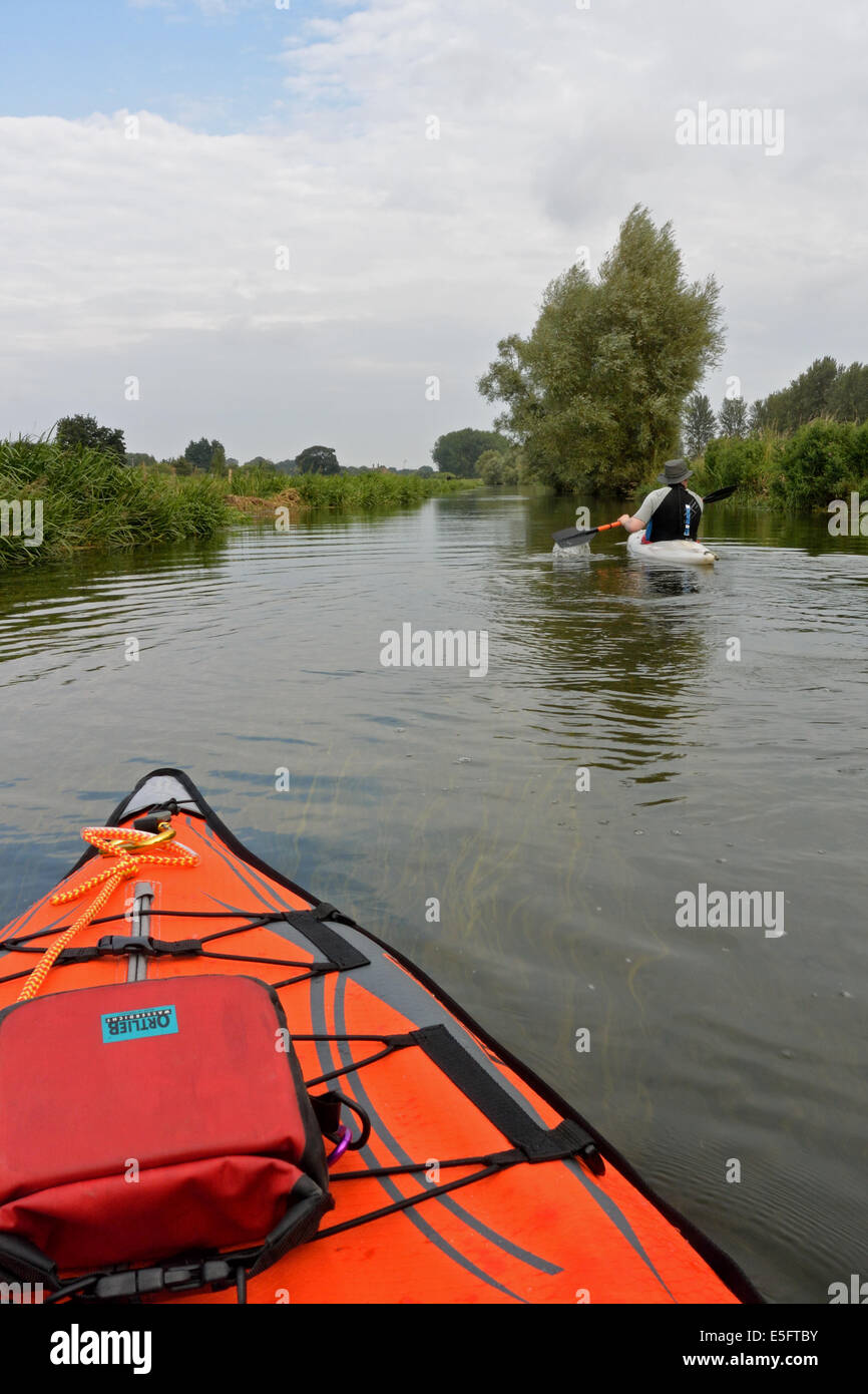 Kayaks paddling on the River Bure between Horstead and Buxton Mill, Norfolk, UK Stock Photo