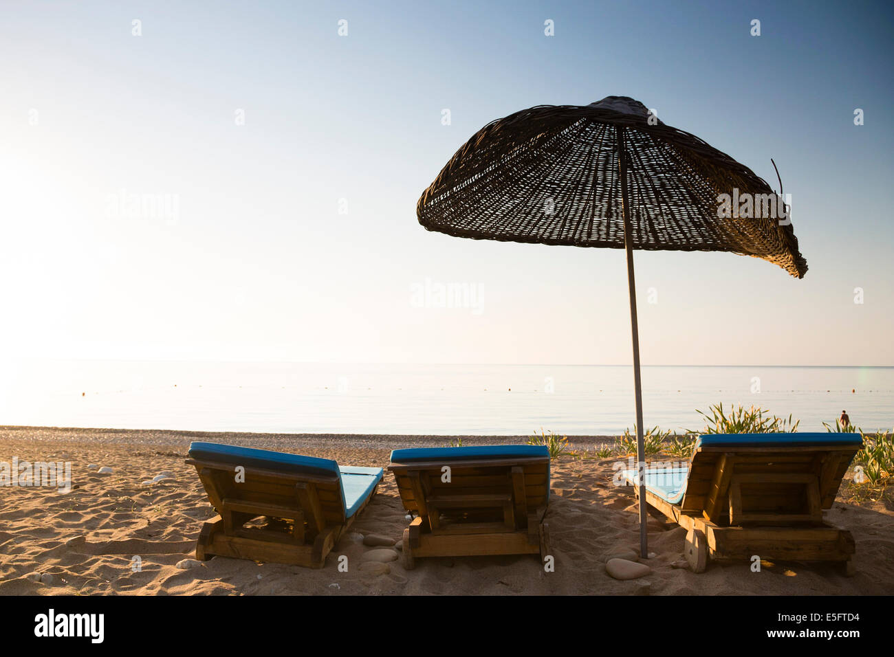 CIRALI, TURKEY Sunloungers on beach at sunrise. Stock Photo