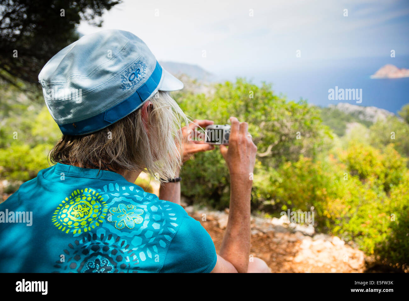 GELIDONIA, TURKEY Exodus trekking client taking photograph of Turquoise Coast on Lycian Way. Stock Photo