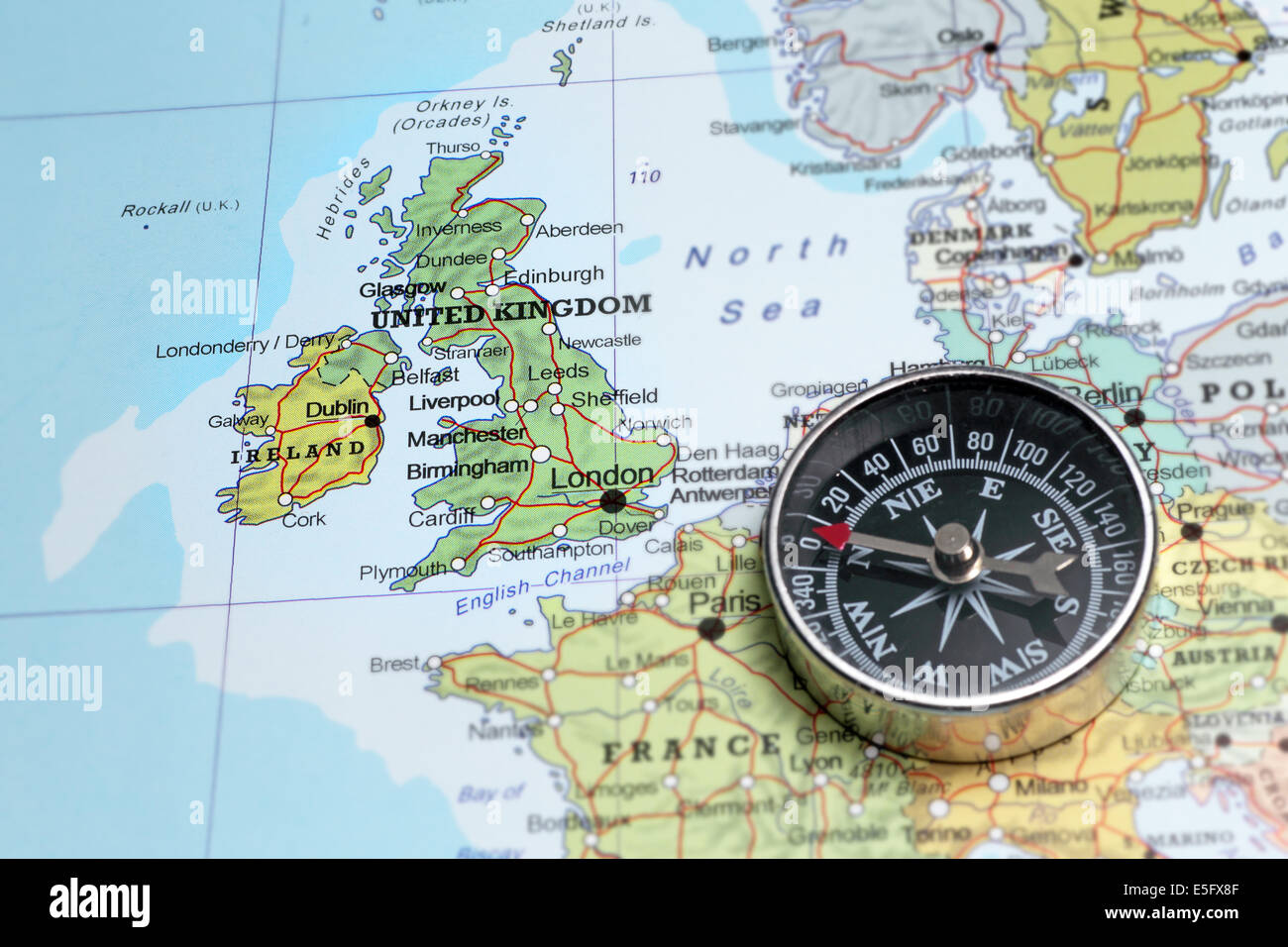 Compass on a map pointing at United Kingdom and Ireland, planning a travel destination Stock Photo