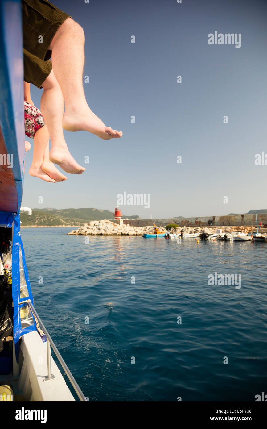 KAS, TURKEY Tourists' feet dangling from upper deck of dive boat. Stock Photo