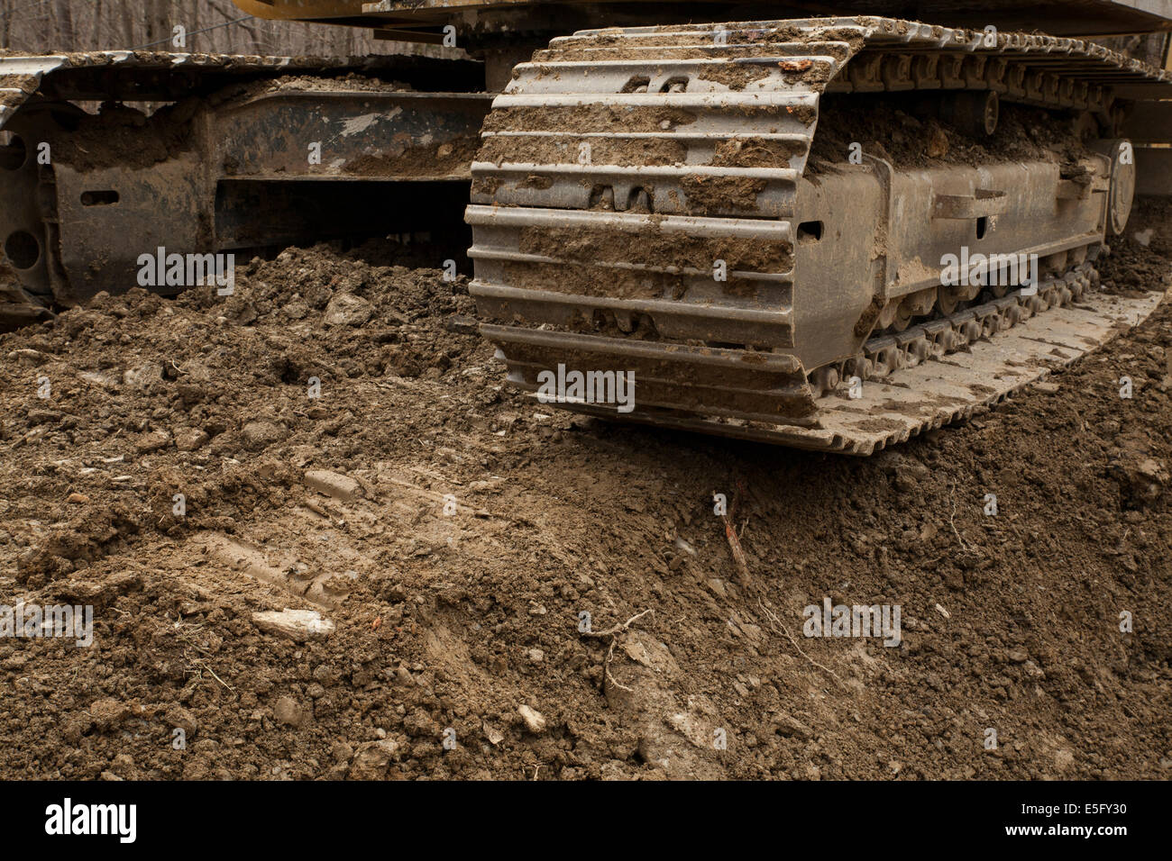 Closeup view of a bulldozer's track and undercarriage, ready to continue with building a home foundation. Stock Photo