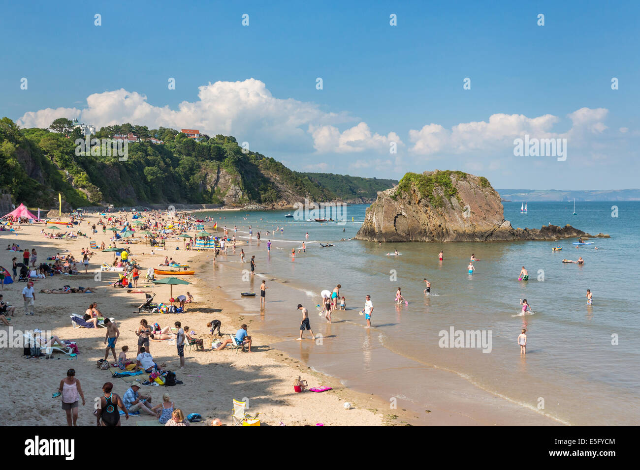 North beach in Tenby packed full of holidaymakers - pictured with Goscar Rock.  Tourism in Wales Stock Photo