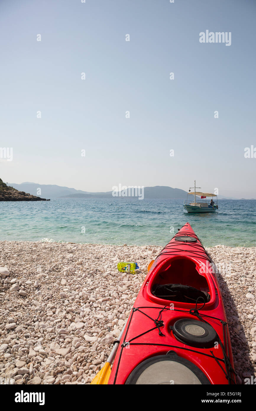 KAS, TURKEY Kayak on beach, boat in background. Stock Photo