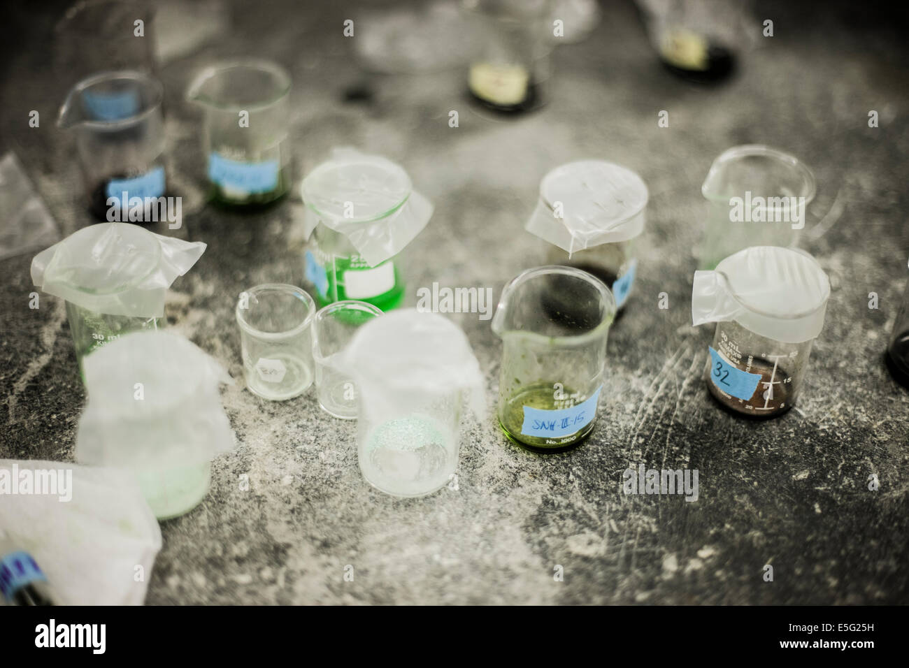 Beakers on messy table Stock Photo