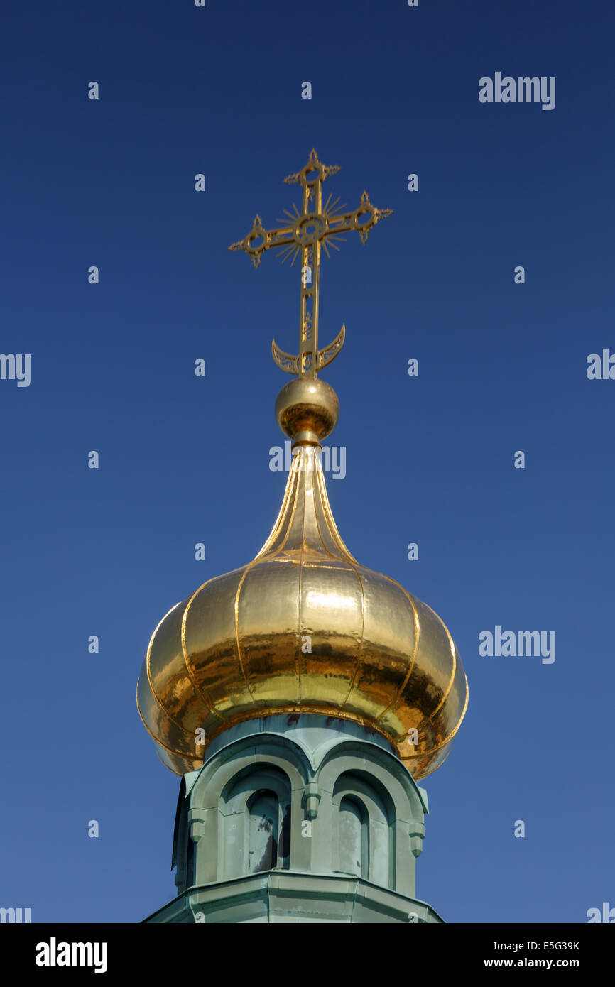 The gilded main onion-shaped dome and cross on top of the Orthodox Uspensky Cathedral in Helsinki. Stock Photo