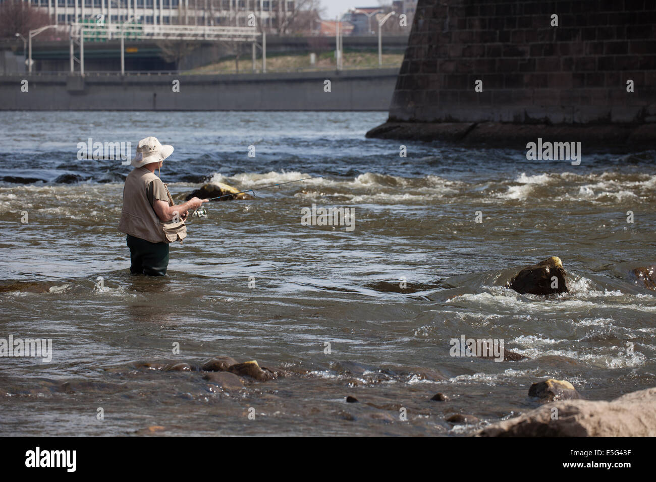 Fisherman under bridge in Delaware River, Trenton, New Jersey Stock