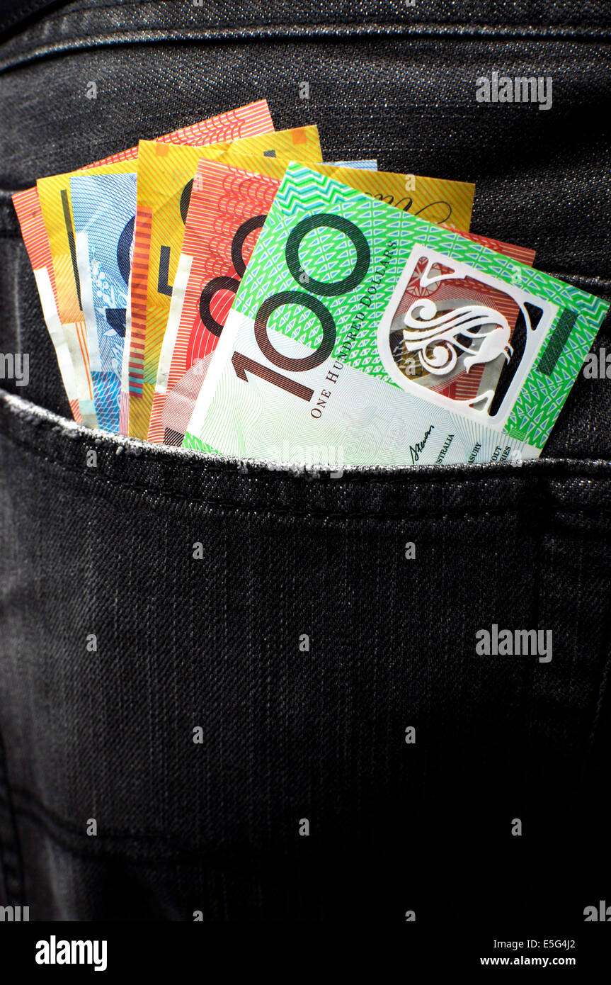 Australian money including 100, 50, 5, 10 and 20 dollar notes, in back pocket of a man's black charcoal jeans pocket. Vertical. Stock Photo
