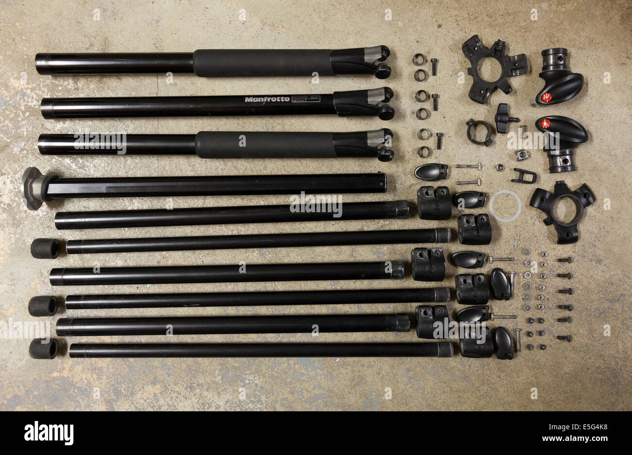 A completely disassembled Manfrotto 055XPROB tripod neatly organized laying on a concrete floor. Ontario, Canada. Stock Photo