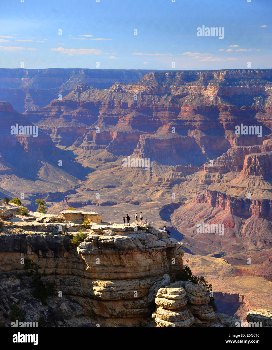 The immense size of the canyon is underlined by the seemingly tiny human figures against the background of the canyon view. Stock Photo