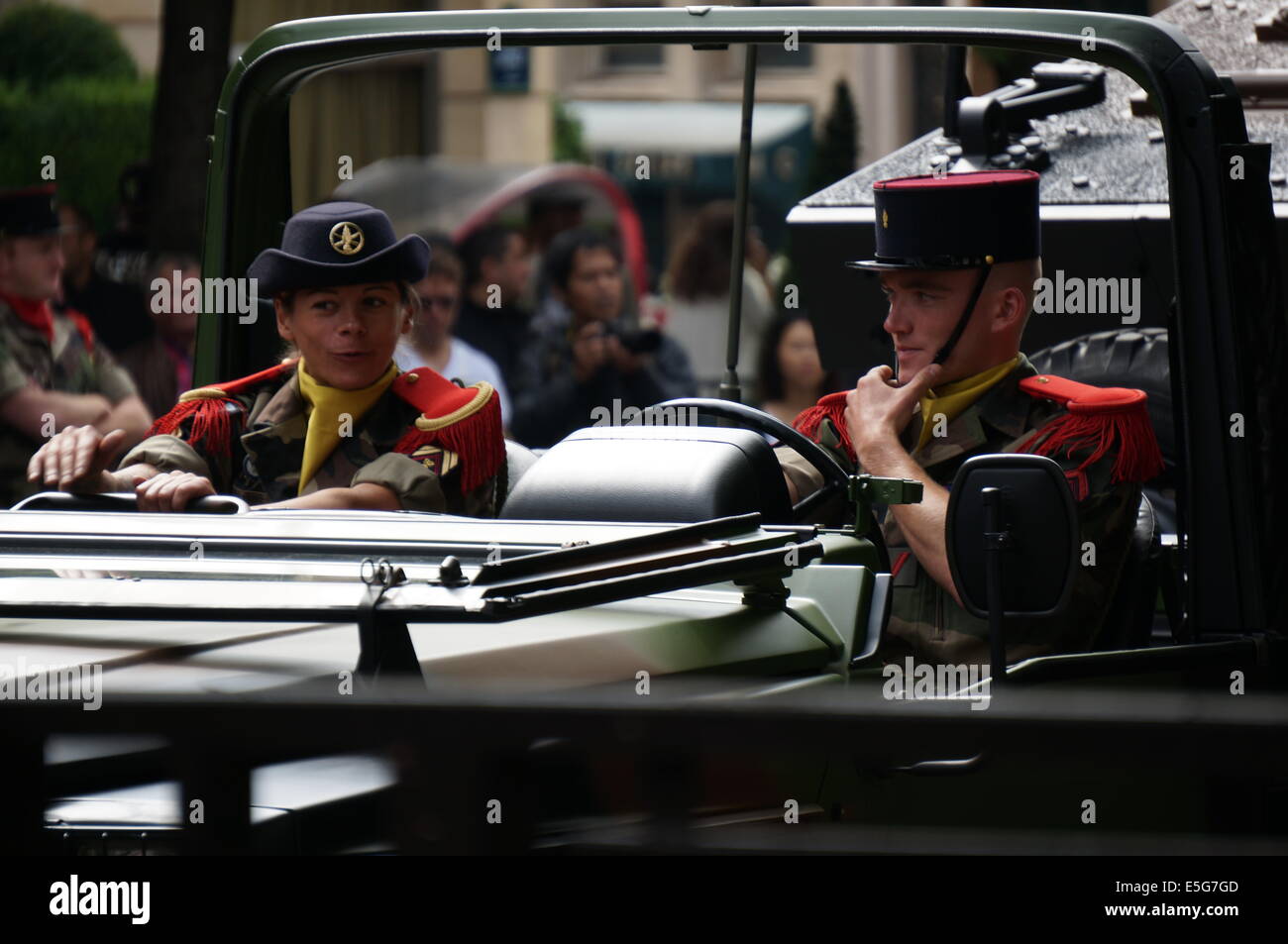 A female soldier and a male soldier in a tank passing down Avenue des Champs Elysees Paris on Bastille Day Stock Photo