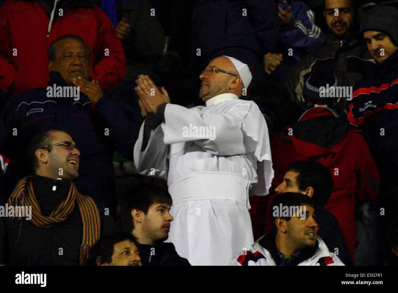 La Paz, Bolivia. 30th July, 2014.  A San Lorenzo fan dressed as Pope Francis watches his team during a second leg of a Copa Libertadores 2014 semi final match at the Hernando Siles Stadium. San Lorenzo won the first leg 5-0; Bolívar the return leg 1-0. Pope Francis is well known for his interest in football / soccer and support for the San Lorenzo team. Credit:  James Brunker / Alamy Live News Stock Photo