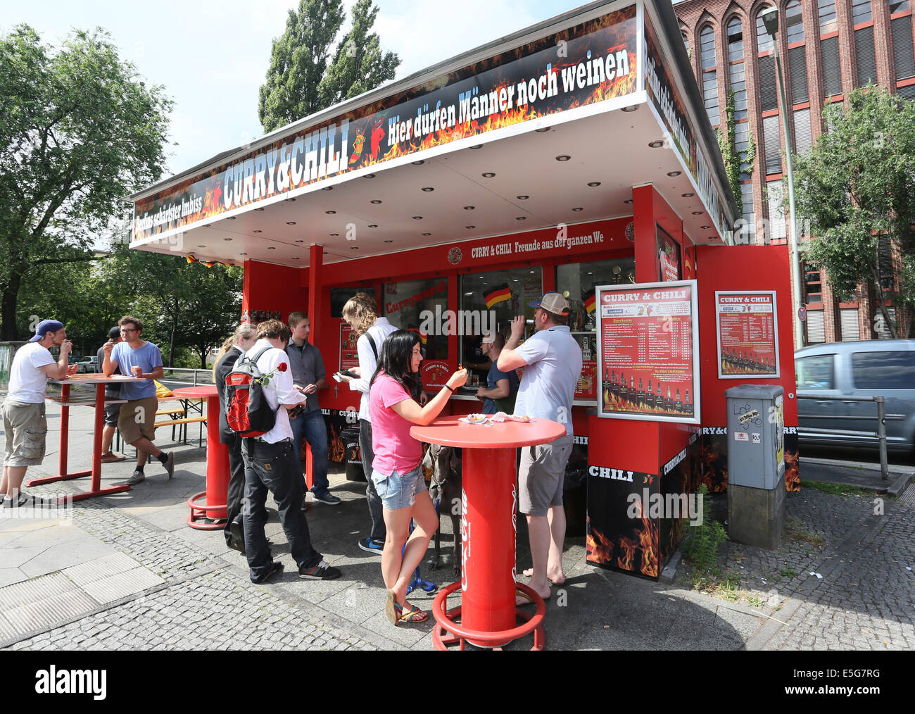 Berlin, Germany. 07th July, 2014. People stand at the snack stand 'Curry & Chily' in Wedding in Berlin, Germany, 07 July 2014. The diner offers curry sausages in varying degrees of spiciness. Customers who eat a meal with the spiciness degree ten can become a member in the curry club and have their portrait shown at the diner. Photo: Stephanie Pilick/dpa/Alamy Live News Stock Photo