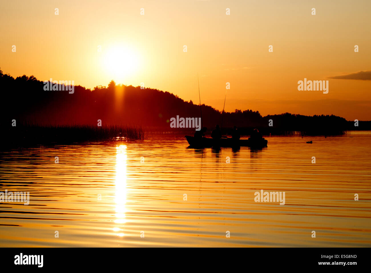 Silhouette of fishing people in boat in sunset time Stock Photo - Alamy