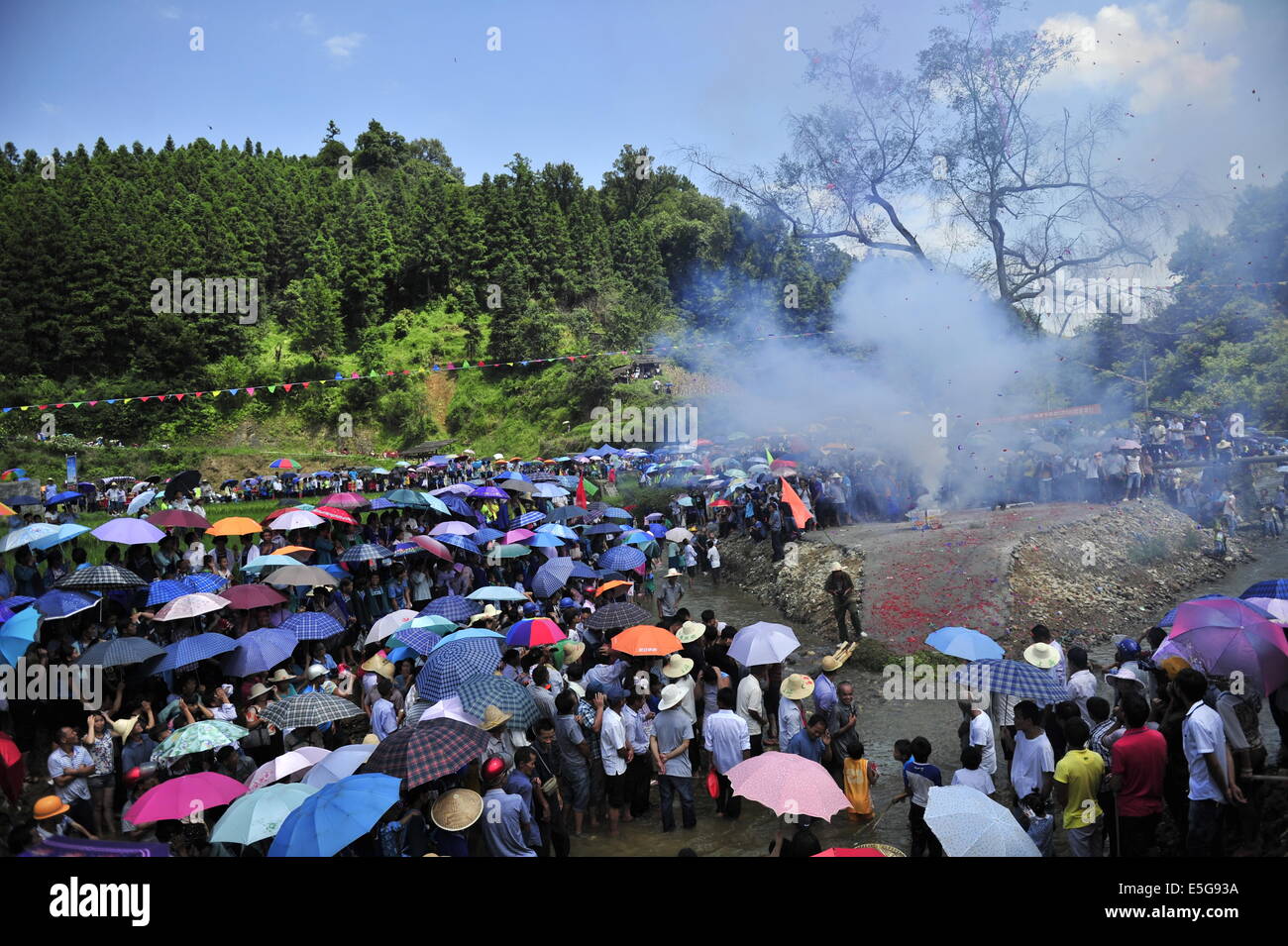 Qiandongnan, China's Guizhou Province. 30th July, 2014. People gather to celebrate the 'Naoyu' Festival in Congjiang County in Qiandongnan Miao and Dong Autonomous Perfecture, southwest China's Guizhou Province, July 30, 2014. 'Naoyu' Festival is a traditional folk custom with a history of over 450 years. People battle for live fish for the wish of harvest and happy life. © Liang Guangyuan/Xinhua/Alamy Live News Stock Photo