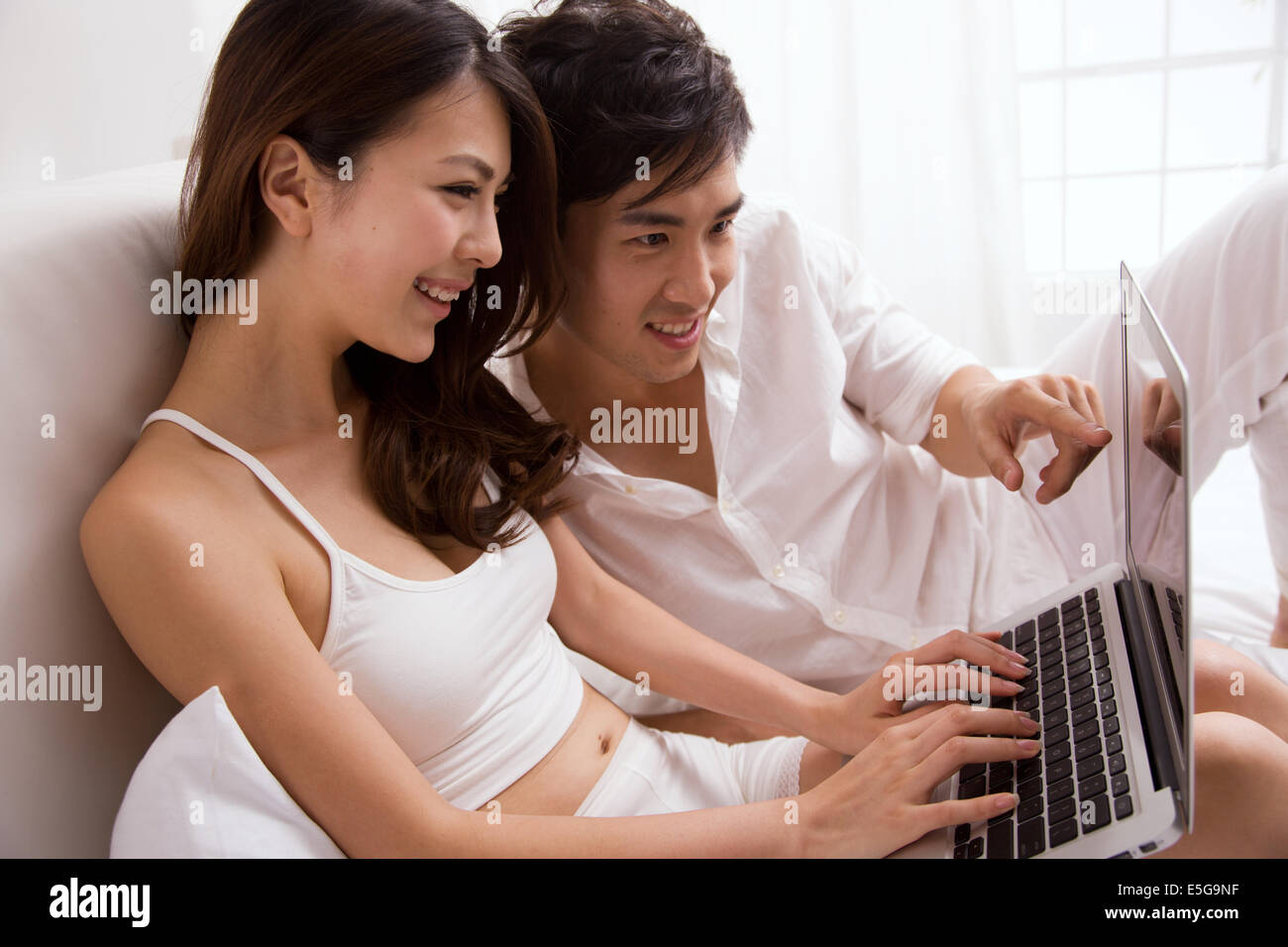 Young couple using laptop Stock Photo - Alamy