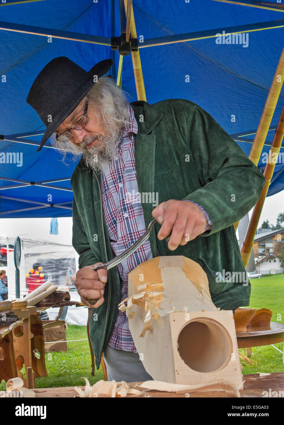 Carving the 'horn of an alphorn from a solid block of wood. Slight motion blur on the carver's hands Stock Photo