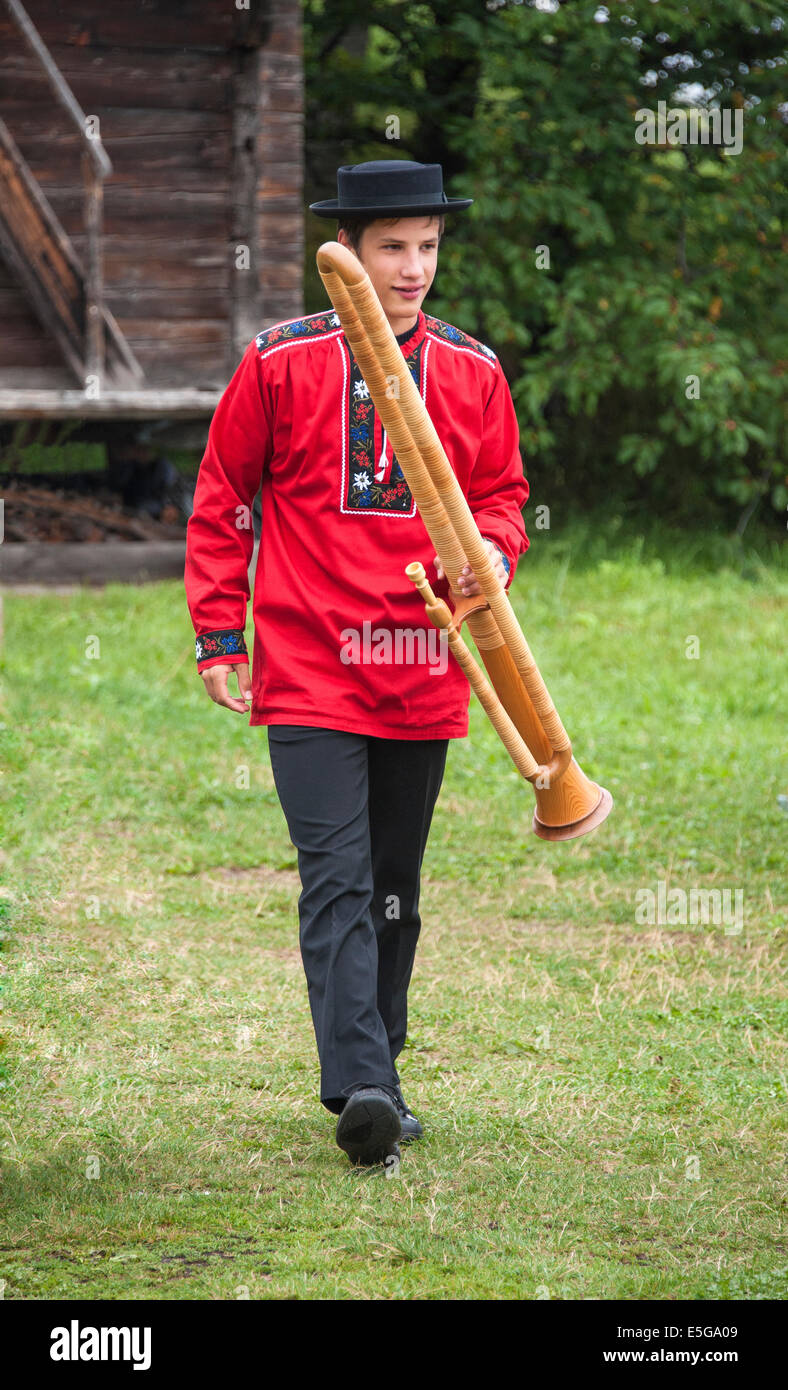 A Swiss musician, in traditional dress, with a buchel, a modified alphorn that is like a double bassoon Stock Photo