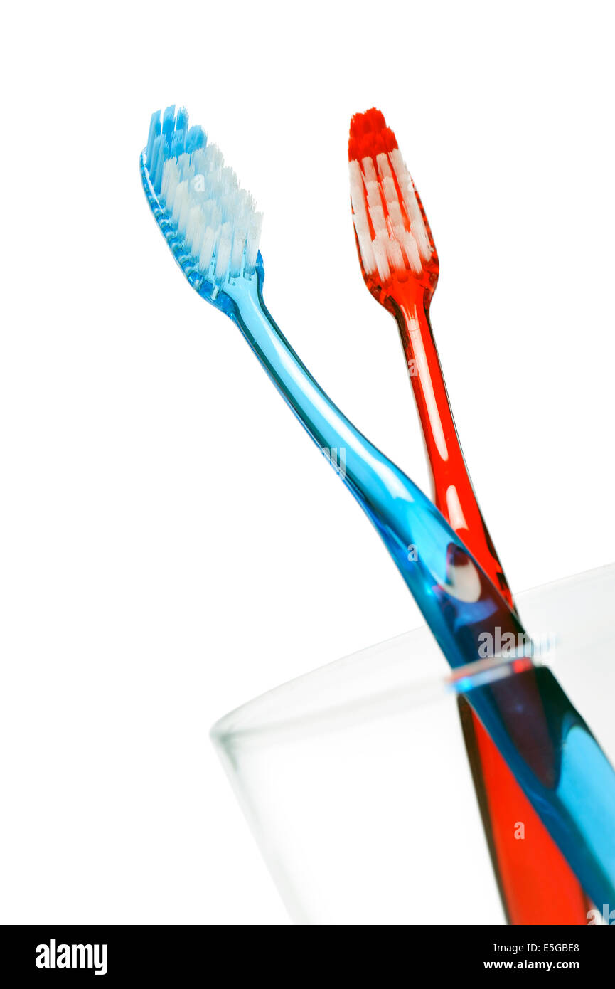pair of toothbrushes in a glass, on white background Stock Photo - Alamy