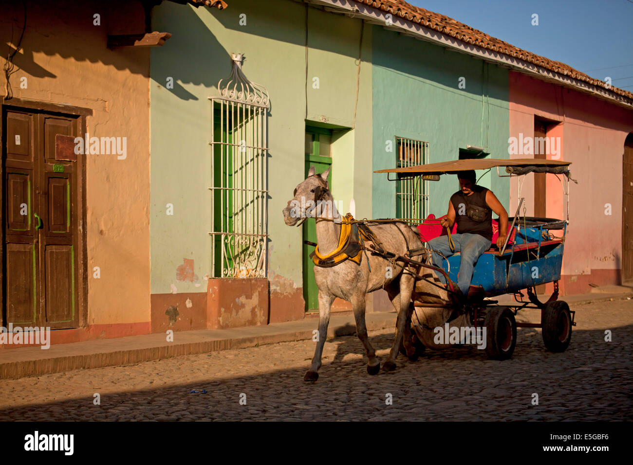 horse carriage in a typical  cobblestone street with colourful homes in the old town of  Trinidad, Cuba, Caribbean Stock Photo