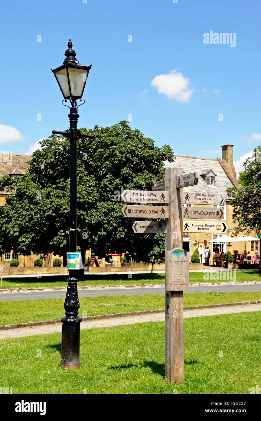 Traditional black streetlight and wooden signpost on the village green ...