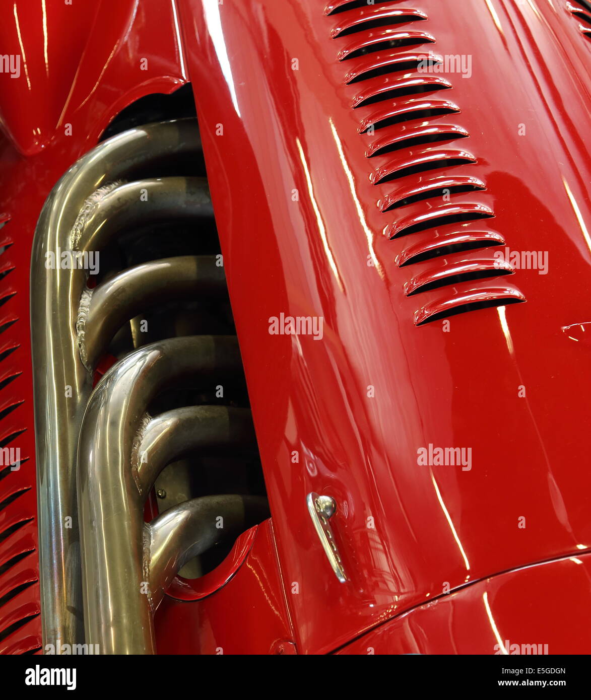 Closeup of the exhaust and bodywork of a red classic racing car Stock