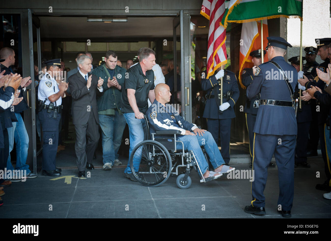 Manhattan, New York, USA. 30th July, 2014. NYPD Detective JOSEPH TROVATO pushes the wheels his partner, injured NYPD Detective MARIO MUNIZ of the Regional Task Force as he is discharged from Bellevue Hospital, Wednesday, July 30, 2014, injured US Marshal RYAN WESTFIELD (center) follows. © Bryan Smith/ZUMA Wire/Alamy Live News Stock Photo