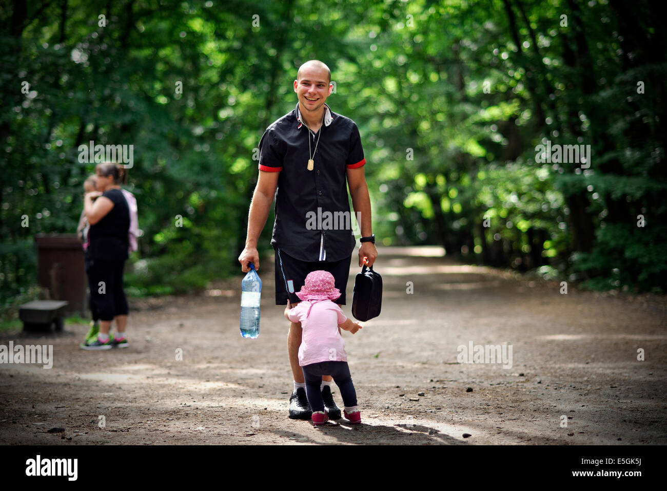 Small girl tries to pass by her father and escape Stock Photo