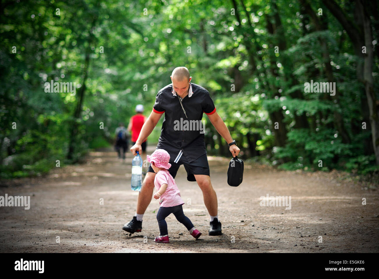 Small girl tries to pass by her father and escape Stock Photo
