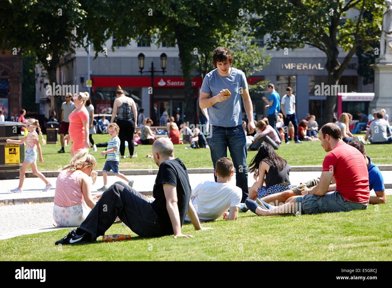 people having lunch enjoying hot summers day in the grounds of Belfast city hall in the city centre Stock Photo