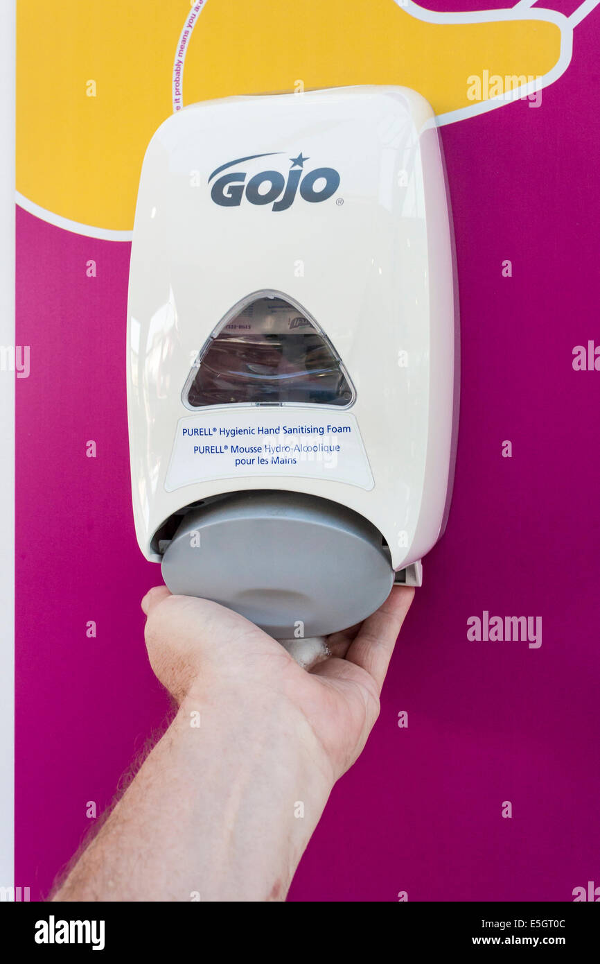 Man's hand using hand hygiene sanitising foam to clean hands in NHS