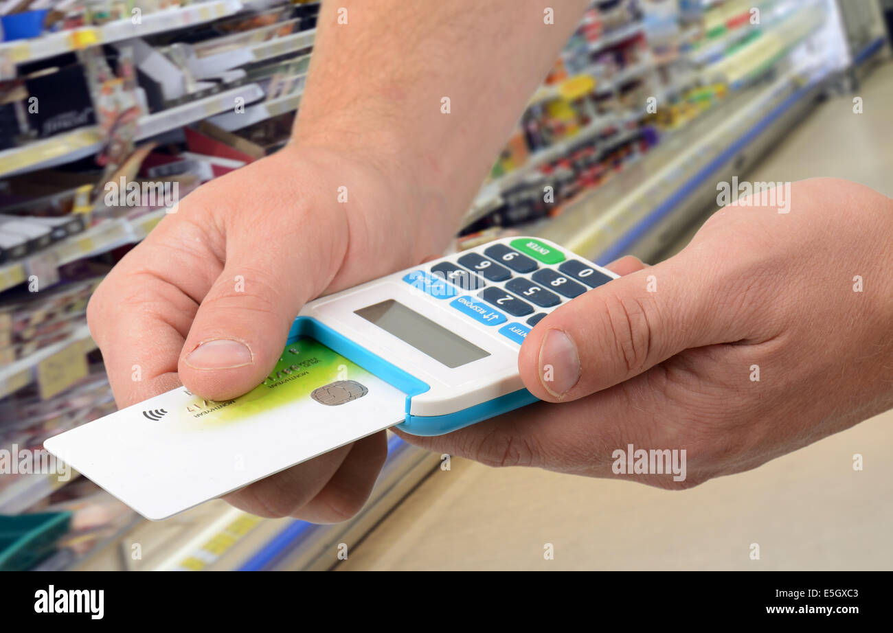 Using a card in card reader for payment in a food shop Stock Photo