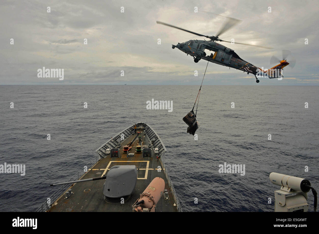 A U.S. Navy MH-60S Seahawk helicopter assigned to Helicopter Combat Support Squadron (HSC) 12 delivers cargo to the guided miss Stock Photo