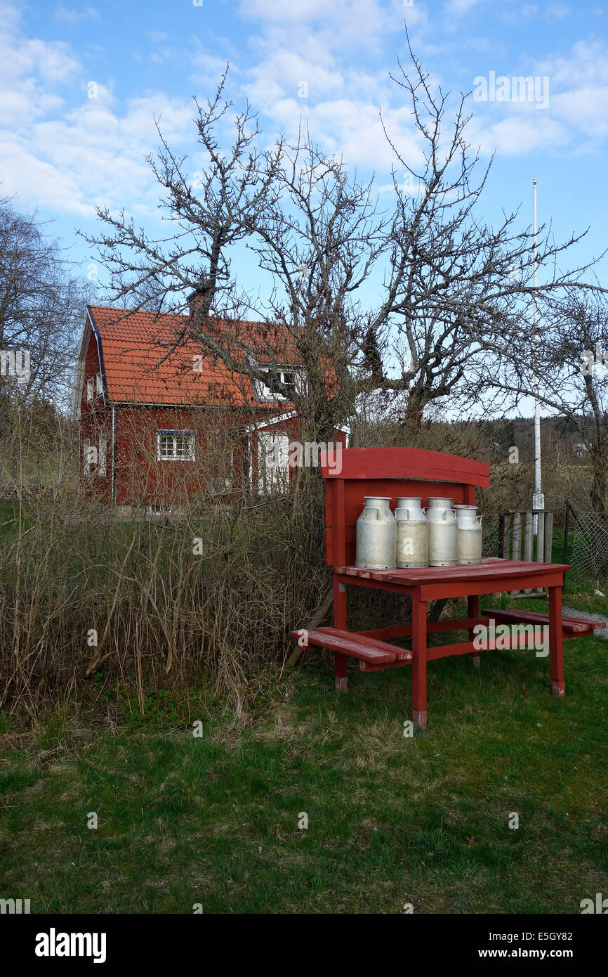 Milk cans have been left on the “milk-board” to be collected by a truck. Nostalgic decoration. Farmstead in Sweden Stock Photo