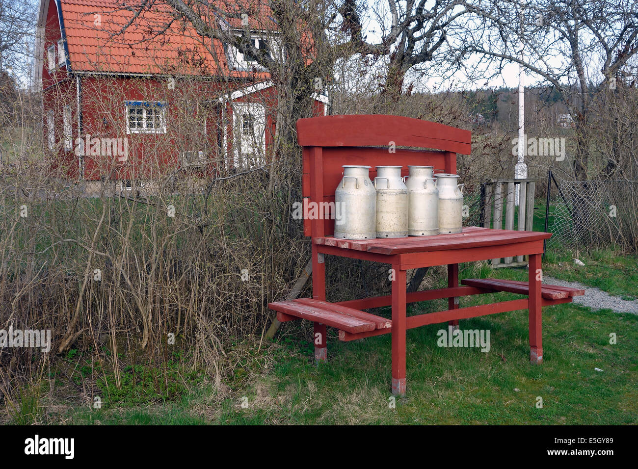Milk cans have been left on the “milk-board” to be collected by a truck. Nostalgic decoration. Farmstead in Sweden Stock Photo