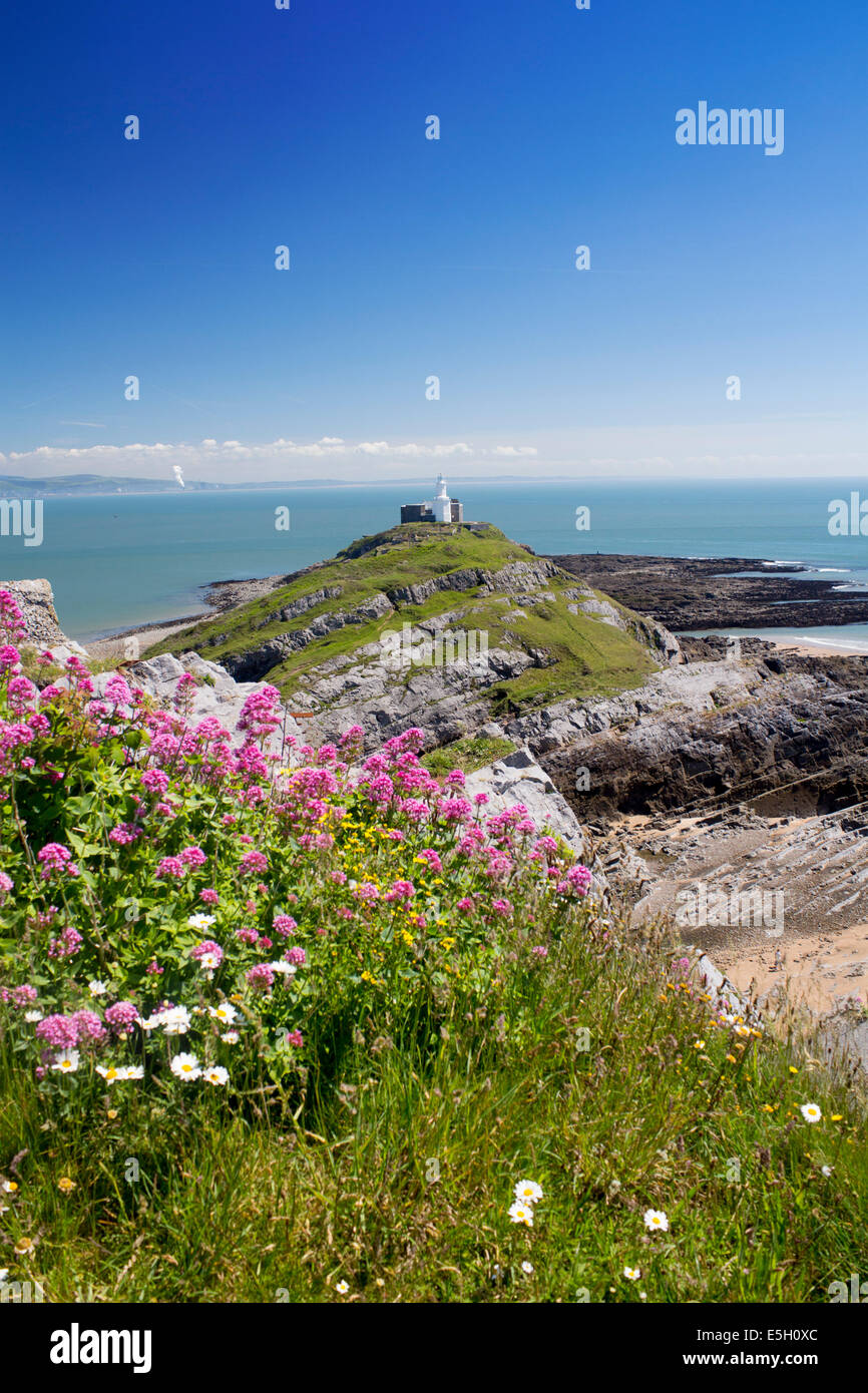 Mumbles Head lighthouse in summer with red valerian flowers in foreground Y Mwmbwls Swansea Abertawe South Wales UK Stock Photo
