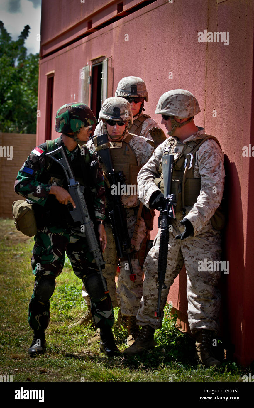 An Indonesian marine, left, and U.S. Marines discuss plans for clearing ...