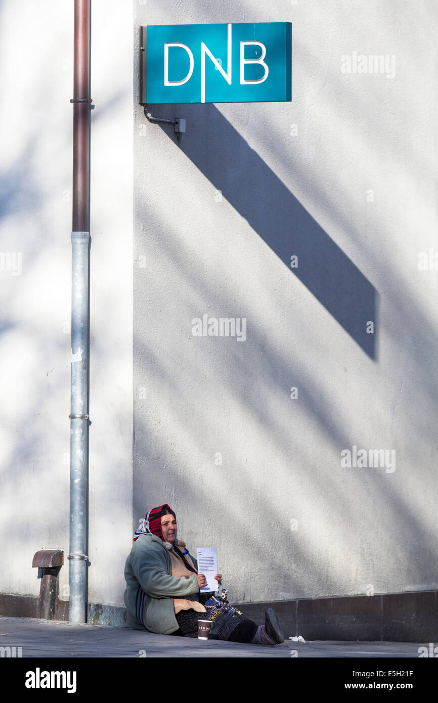 Stavanger, Rogaland, Norway. 25th of Feb, 2014. Romani woman begging outside DNB ('Den Norske Bank' - The Norwegian Bank). Stock Photo