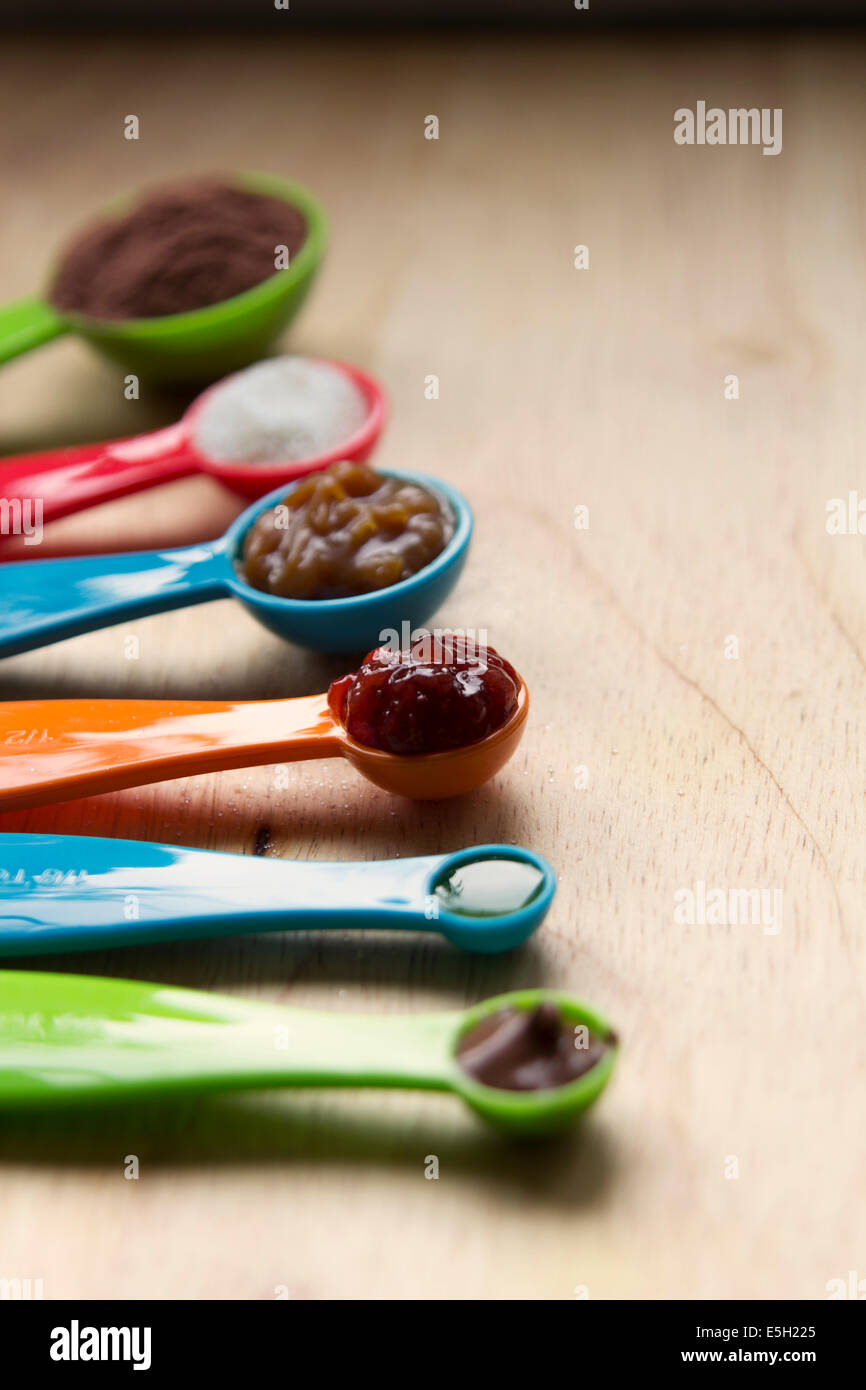Different kinds of topping for displayed on spoons on wood Stock Photo ...