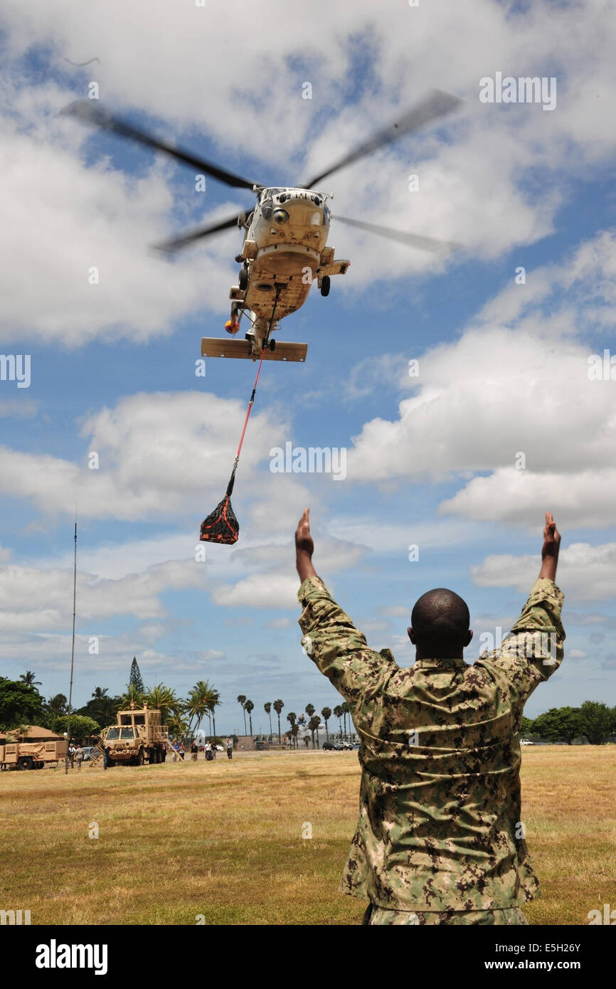 A Japan Maritime Self-Defense Force SH-60K Seahawk helicopter airlifts relief supplies during humanitarian assistance/disaster Stock Photo