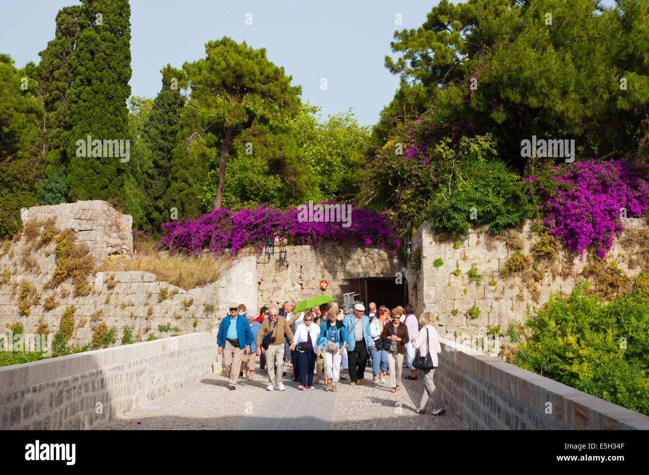 Tourist group with a guide going over the moat into th old town at Liberty gate, Rhodes town, Rhodes island, Dodecanese islands, Stock Photo