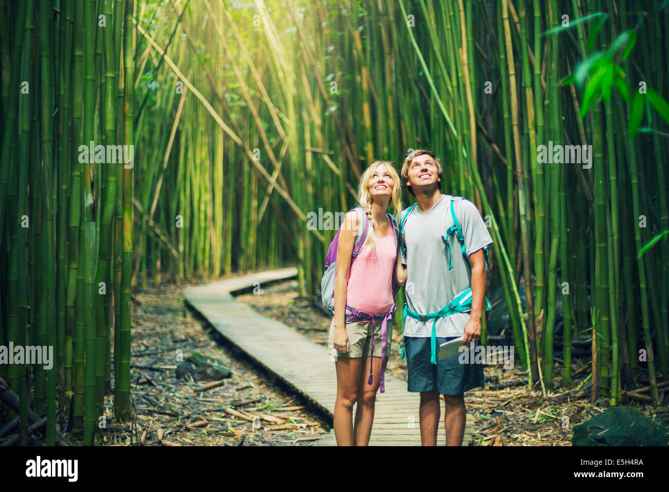 Couple having fun together outdoors on hike through amazing bamboo forest trail. Stock Photo